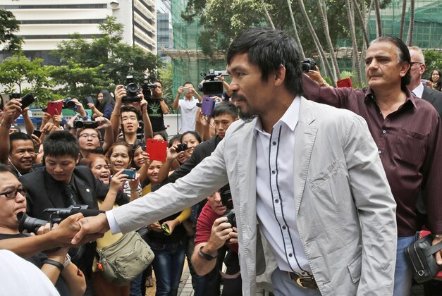 Filipino boxing champion Manny Pacquiao shakes hands with his fan during a promotional tour for his upcoming WBO welterweight boxing match, in Hong Kong, Sunday, Oct. 26, 2014.  Pacquiao will fight with Chris Algieri of the U.S. in their WBO welterweight title bout in Macau on Nov. 22. (AP Photo/Kin Cheung)