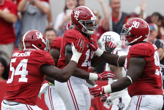 Oct 18, 2014; Tuscaloosa, AL, USA; Alabama Crimson Tide linebacker Reggie Ragland (19) is congratulated by teammates after he intercepted a pass from Texas A&M Aggies quarterback Kenny Hill (not shown) at Bryant-Denny Stadium. The Crimson Tide defeated the Aggies 59-0. Mandatory Credit: Marvin Gentry-USA TODAY Sports
