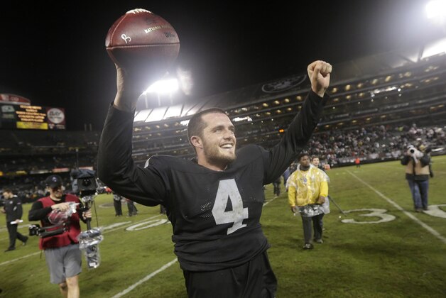 Oakland Raiders quarterback Derek Carr (4) celebrates after the Raiders beat the Kansas City Chiefs in an NFL football game in Oakland, Calif., Thursday, Nov. 20, 2014. The Raiders won 24-20.  (AP Photo/Marcio Jose Sanchez)