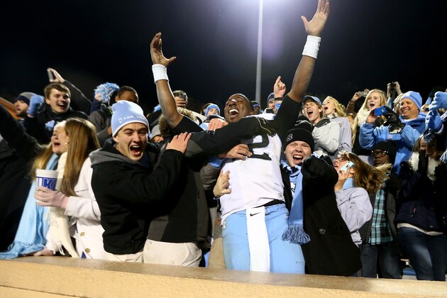 DURHAM, NC - NOVEMBER 20:  Marquise Williams #12 of the North Carolina Tar Heels celebrates with the fans after defeating the Duke Blue Devils 45-20 at Wallace Wade Stadium on November 20, 2014 in Durham, North Carolina.  (Photo by Streeter Lecka/Getty Images)