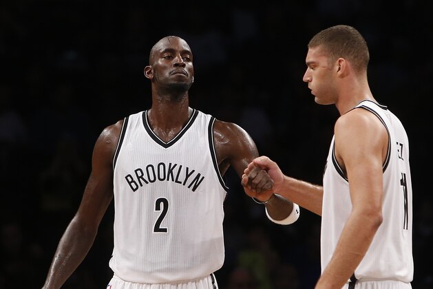 Brooklyn Nets' Kevin Garnett (2) celebrates with teammate Brook Lopez, right, during the third quarter of an NBA preseason basketball game against the Maccabi Tel Aviv Tuesday, Oct. 7, 2014, in New York.  Brooklyn won 111-94. (AP Photo/Jason DeCrow)