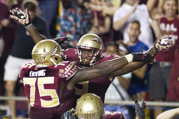 Florida State running back Karlos Williams, top, celebrates his game-winning touchdown in overtime with teammates Cameron Erving, center, and Bobby Hart after an NCAA college football game against Clemson in Tallahassee, Fla., Saturday, Sept. 20, 2014.  Florida State defeated Clemson 23-17 in overtime. (AP Photo/Mark Wallheiser)