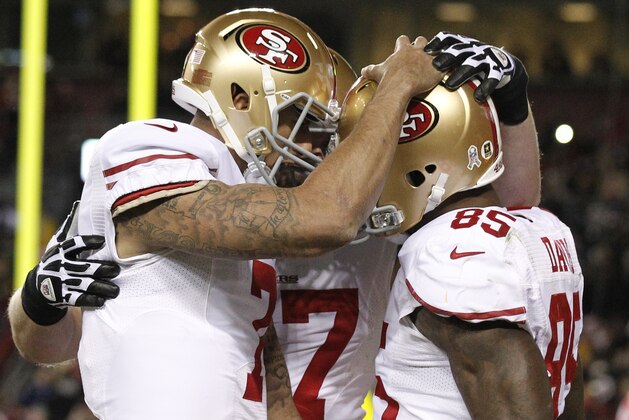 San Francisco 49ers quarterback Colin Kaepernick, left, congratulates tight end Vernon Davis on his touchdown catch during the second half of an NFL football game against the Washington Redskins in Landover, Md., Monday, Nov. 25, 2013. (AP Photo/Alex Brandon)
