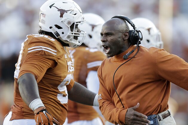 Texas Longhorns head coach Charlie Strong, right, celebrates with Malcom Brown, left, during the second half of an NCAA college football game against West Virginia, Saturday, Nov. 8, 2014, in Austin, Texas.  Texas won 33-16. (AP Photo/Eric Gay)