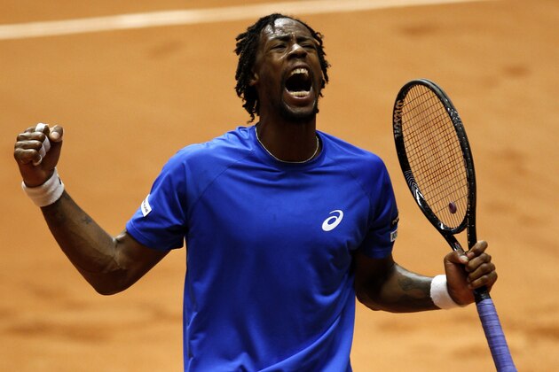 France's Gael Monfils celebrates a winning point as he plays Switzerland's Roger Federer during the  Davis Cup final in Lille, northern France, Friday, Nov.21, 2014. (AP Photo/Peter Dejong)