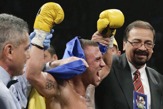 Vasyl Lomachenko, center, is declared the winner by knockout over Jose Ramirez in the fourth round during a WBO International featherweight title fight, Saturday, Oct. 12, 2013, in Las Vegas. (AP Photo/Julie Jacobson)