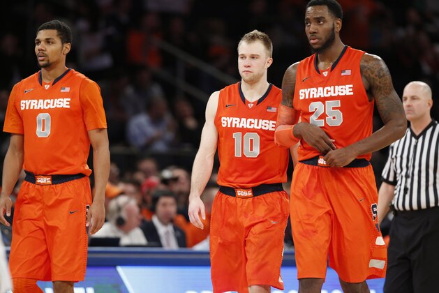 Syracuse guards Michael Gbinije (0), and Trevor Cooney (10) retreat to the bench with forward Rakeem Christmas (25) during a timeout in the latter part of the second half of an NCAA basketball game at Madison Square Garden in New York, Thursday, Nov. 20, 2014. California defeated Syracuse 73-59. (AP Photo/Kathy Willens)