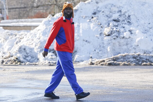 Buffalo Bills' Mike Williams walks through a parking lot to the team charter flight for Detroit at the Buffalo Niagara International Airport, Friday, Nov. 21, 2014, in Cheektowaga, N.Y.  Snowed out in Buffalo, the Bills are heading to Detroit to play their