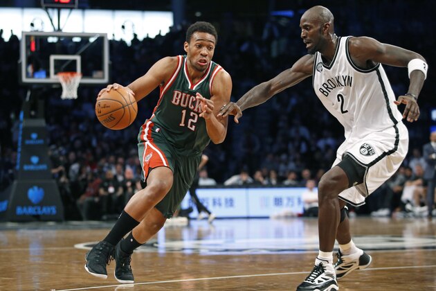 Milwaukee Bucks forward Jabari Parker (12) drives past Brooklyn Nets forward Kevin Garnett (2) during the first half of an NBA basketball game Wednesday, Nov. 19, 2014, in New York. (AP Photo/Kathy Willens)