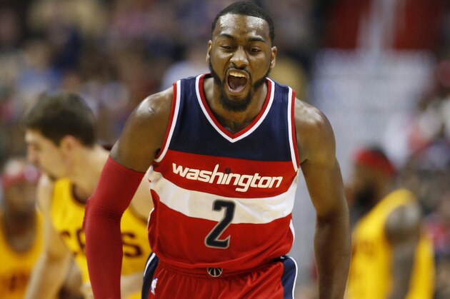 Washington Wizards guard John Wall reacts after a score in the first half of an NBA basketball game against the Cleveland Cavaliers, Friday, Nov. 21, 2014, in Washington. (AP Photo/Alex Brandon)