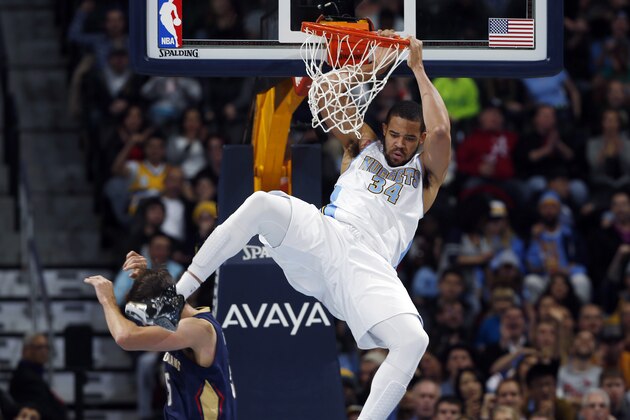 Denver Nuggets center JaVale McGee, top, hangs from rim after dunking a ball for a basket over New Orleans Pelicans center Jeff Withey in the fourth quarter of the Nuggets' 117-97 victory in an NBA basketball game in Denver on Friday, Nov. 21, 2014. (AP Photo/David Zalubowski)