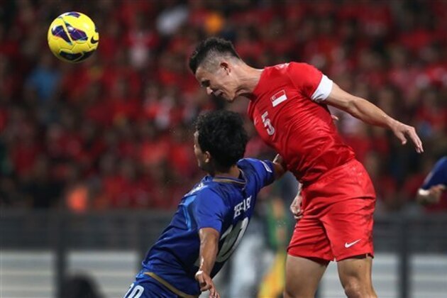 Singapore's Baihakki Khaizan, right, and Thailand's Teerasil Dangda, left, go for a header during the AFF Suzuki Cup 2012 Final 1st Leg soccer match between Singapore and Thailand on Wednesday Dec. 19, 2012 in Singapore. (AP Photo/Wong Maye-E)