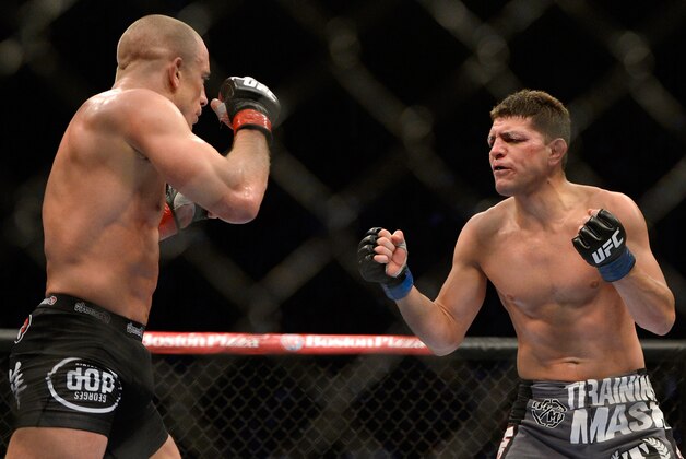 Mar 16, 2013; Montreal, Quebec, CAN;  Nick Diaz (blue) taunts Georges St.Pierre (red) during their Welterweight title bout at UFC 158 at the Bell Centre. Mandatory Credit: Eric Bolte-USA TODAY Sports