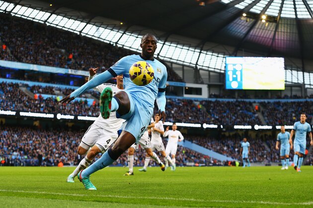 MANCHESTER, ENGLAND - NOVEMBER 22: Yaya Toure of Manchester City keeps the ball in play during the Barclays Premier League match between Manchester City and Swansea City at Etihad Stadium on November 22, 2014 in Manchester, England.  (Photo by Jan Kruger/Getty Images)