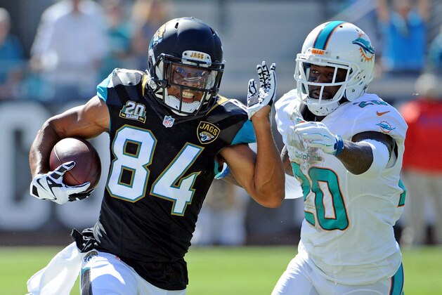 Oct 26, 2014; Jacksonville, FL, USA; Jacksonville Jaguars wide receiver Cecil Shorts III (84) runs the ball past Miami Dolphins safety Reshad Jones (20) during the first half of the game at EverBank Field. Mandatory Credit: Melina Vastola-USA TODAY Sports