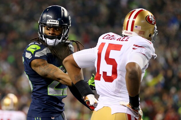 SEATTLE, WA - JANUARY 19:  Cornerback Richard Sherman #25 of the Seattle Seahawks talks with the referee after being called for an unsportsmanlike penalty for taunting wide receiver Michael Crabtree #15 of the San Francisco 49ers late in the fourth quarter during the 2014 NFC Championship at CenturyLink Field on January 19, 2014 in Seattle, Washington.  (Photo by Ronald Martinez/Getty Images)