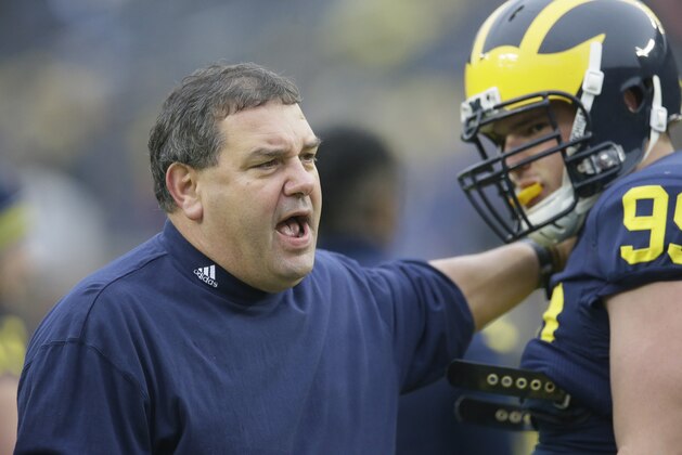 Michigan head coach Brady Hoke talks with defensive tackle Matthew Godin during warmups before the NCAA college football game against Maryland in Ann Arbor, Mich., Saturday, Nov. 22, 2014. (AP Photo/Carlos Osorio)
