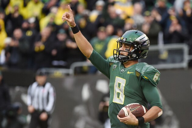Oregon quarterback Marcus Mariota (8) celebrates after scoring a touchdown during the first quarter of an NCAA college football game against the Colorado on Saturday, Nov. 22, 2014, in Eugene, Ore. (AP Photo/Steve Dykes)