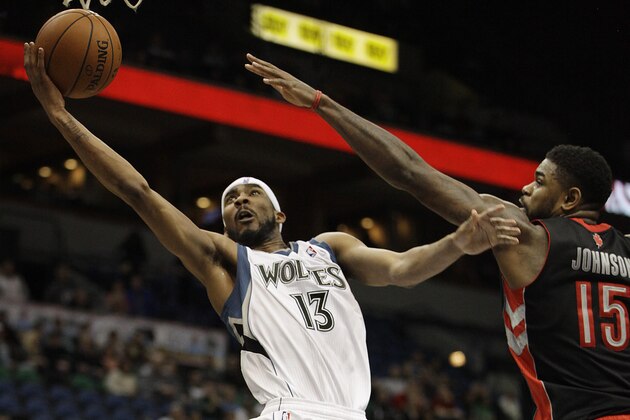Minnesota Timberwolves forward Corey Brewer (13) goes up to the basket against Toronto Raptors forward Amir Johnson (15) in the second half of an NBA basketball game, Sunday, March 9, 2014, in Minneapolis. The Raptors won 111-104. (AP Photo/Stacy Bengs)