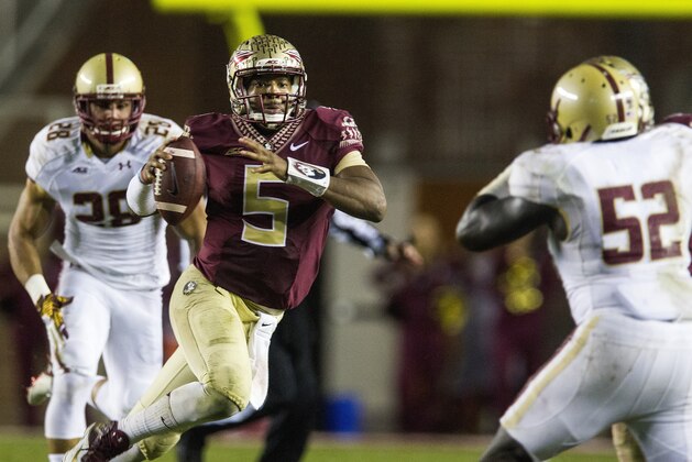 Florida State quarterback Jameis Winston, center, scrambles past Boston College defenders Matt Milano, left, and Steven Daniels in the second half of an NCAA college football game in Tallahassee, Fla., Saturday, Nov. 22, 2014. Florida State defeated Boston College 20-17.  (AP Photo/Mark Wallheiser)