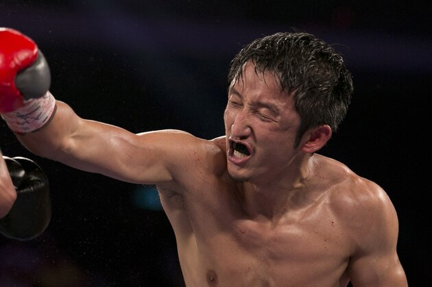 In this July 27, 2013 photo, China's Zou Shiming, right, fights against Mexico's Jesus Ortega during their Flyweight bout at the Cotai Arena in Venetian Macao in Macau. The Chinese fighter’s victory at a Macau showdown brings the world’s top casino market a step closer to challenging Las Vegas for dominance of another Sin City staple: big-time boxing matches. Macau, which long ago eclipsed Vegas as the world's top gambling city, is now looking to add to its allure by holding the kind of boxing bouts that Las Vegas is known for. (AP Photo/Dennis Ho)