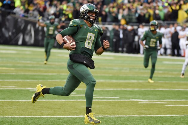 Oregon quarterback Marcus Mariota (8) runs in for a touchdown during the first quarter of an NCAA college football game against the Colorado on Saturday, Nov. 22, 2014, in Eugene, Ore. (AP Photo/Steve Dykes)