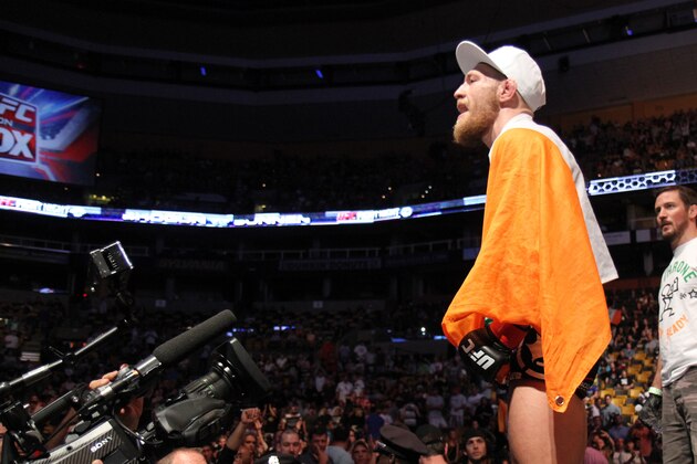 Conor McGregor, of Ireland, leaves the ring draped in an Irish flag after beathing Max Holloway in their UFC on Fox Sports 1 mixed martial arts bout in Boston, Saturday, August 17,2013. McGregor won via unanimous decision. (AP Photo/Gregory Payan)