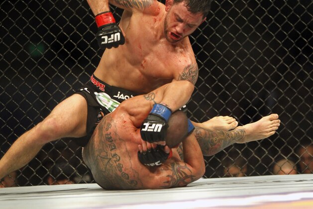 Frankie Edgar, top, strikes Cub Swanson in a featherweight mixed martial arts bout during the UFC Fight Night at the Frank Erwin Center in Austin, Texas, Sunday, Nov. 23, 2014. (AP Photo/Michael Thomas)