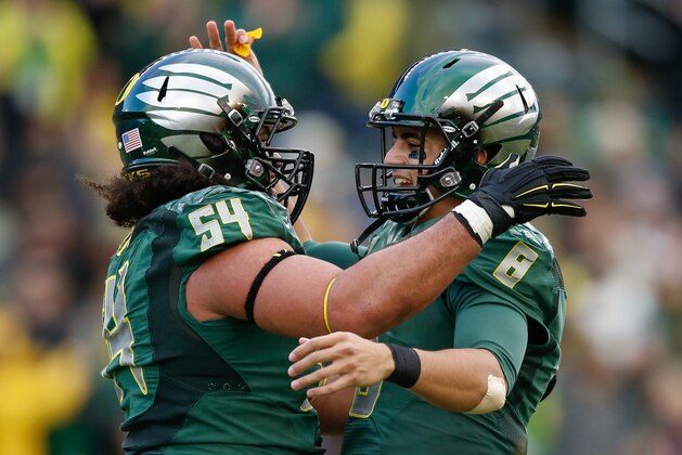 EUGENE, OR - NOVEMBER 22:  Quarterback Marcus Mariota #8 of the Oregon Ducks is congratulated by Hamani Stevens #54 after throwing a touchdown pass to tight end Evan Baylis in the third quarter against the Colorado Buffaloes at Autzen Stadium on November 22, 2014 in Eugene, Oregon. The Ducks defeated the Buffaloes 44-10.  (Photo by Otto Greule Jr/Getty Images)