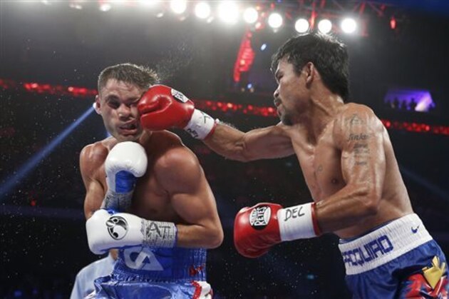 WBO welterweight champion Manny Pacquiao, right, of the Philippines lands a right on the face of WBO junior welterweight champion Chris Algieri of the United States during their welterweight boxing title fight at the Venetian Macao in Macau, Sunday, Nov. 23, 2014. (AP Photo/Kin Cheung)