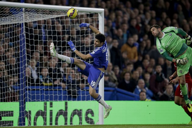 Chelsea's Diego Costa, left, attempts to get his foot to the ball as it is cleared by West Bromwich Albion's goalkeeper Ben Foster, right, during the English Premier League soccer match between Chelsea and West Bromwich Albion at Stamford Bridge stadium in London, Saturday, Nov. 22, 2014.  (AP Photo/Matt Dunham)