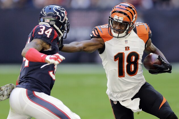 Cincinnati Bengals' A.J. Green (18) tries to avoid Houston Texans' A.J. Bouye (34) as he runs with the ball during the first quarter of an NFL football game, Sunday, Nov. 23, 2014, in Houston. (AP Photo/Patric Schneider)