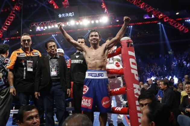 WBO welterweight champion Manny Pacquiao, center, celebrates after defeating WBO junior welterweight champion Chris Algieri of the United States during their welterweight title boxing match at the Venetian Macao in Macau, Sunday, Nov. 23, 2014. Pacquiao got the big knockdowns he desperately craved, battering Algieri around the ring Sunday on his way to a decision win in a lopsided welterweight title fight.(AP Photo/Kin Cheung)