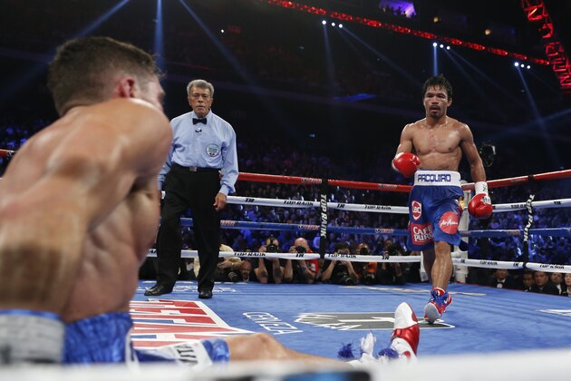 WBO junior welterweight champion Chris Algieri of the United States sits on the mat after being knocked down by WBO welterweight champion Manny Pacquiao of the Philippines during their WBO welterweight boxing match at the Venetian Macao in Macau, Sunday, Nov. 23, 2014. (AP Photo/Kin Cheung)