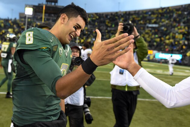 Oregon quarterback Marcus Mariota (8) greets a Colorado player after an NCAA college football game on Saturday, Nov. 22, 2014, in Eugene, Ore. (AP Photo/Steve Dykes)