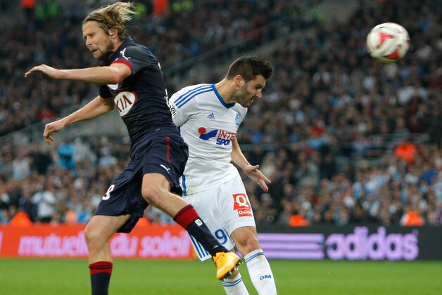 Marseille's French forward Andre-Pierre Gignac, right, scores against Bordeaux, despite Bordeaux's midfielder Jaroslav Plasil of Czech Republic during their League One soccer match, at the Velodrome Stadium, in Marseille, southern France, Sunday, Nov. 23, 2014. (AP Photo/Claude Paris)