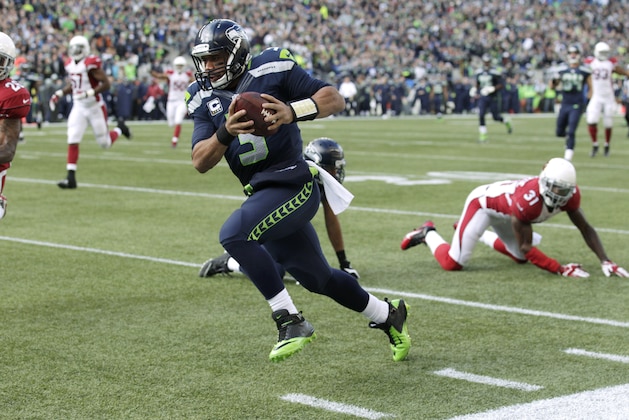 Seattle Seahawks quarterback Russell Wilson makes a long run to near the end zone against the Arizona Cardinals in the first half of an NFL football game, Sunday, Nov. 23, 2014, in Seattle, but the play was called back due to a holding penalty against the Seahawks.(AP Photo/Stephen Brashear)