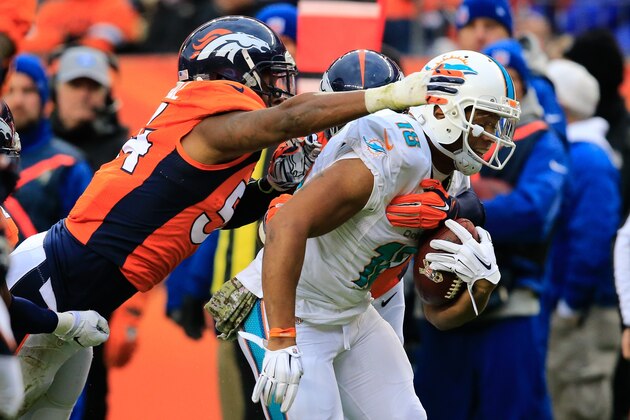 DENVER, CO - NOVEMBER 23:  Wide receiver Rishard Matthews #18 of the Miami Dolphins is tackled by outside linebacker Brandon Marshall #54 of the Denver Broncos during a game at Sports Authority Field at Mile High on November 23, 2014 in Denver, Colorado.  (Photo by Doug Pensinger/Getty Images)
