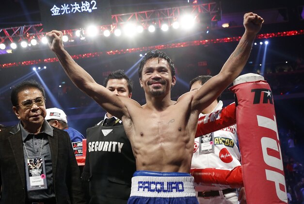 WBO welterweight champion Manny Pacquiao celebrates after defeating WBO junior welterweight champion Chris Algieri of the U.S.  during their welterweight title boxing match at the Venetian Macao in Macau, Sunday, Nov. 23, 2014. Pacquiao got the big knockdowns he desperately craved, battering Algieri around the ring Sunday on his way to a decision win in a lopsided welterweight title fight.(AP Photo/Kin Cheung)
