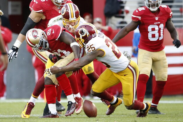 San Francisco 49ers running back Frank Gore (21) loses a fumble, which was recovered by Washington Redskins strong safety Phillip Thomas, not pictured, during the fourth quarter of an NFL football game in Santa Clara, Calif., Sunday, Nov. 23, 2014. (AP Photo/Tony Avelar)