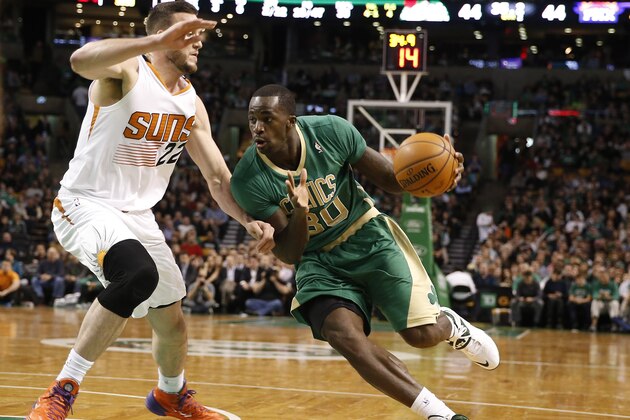Boston Celtics forward Brandon Bass (30) drives on Phoenix Suns center Miles Plumlee during the second quarter of an NBA basketball game in Boston Friday, March 14, 2014. (AP Photo/Winslow Townson)