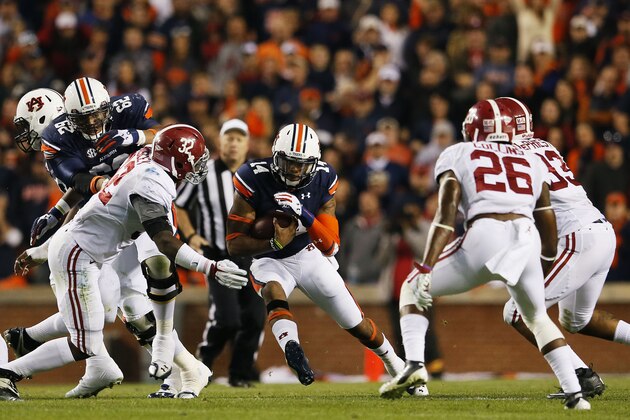 AUBURN, AL - NOVEMBER 30:  Nick Marshall #14 of the Auburn Tigers runs the ball against C.J. Mosley #32 of the Alabama Crimson Tide in the second quarter at Jordan-Hare Stadium on November 30, 2013 in Auburn, Alabama.  (Photo by Kevin C. Cox/Getty Images)
