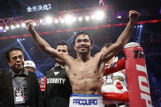 WBO welterweight champion Manny Pacquiao celebrates after defeating WBO junior welterweight champion Chris Algieri of the U.S.  during their welterweight title boxing match at the Venetian Macao in Macau, Sunday, Nov. 23, 2014. Pacquiao got the big knockdowns he desperately craved, battering Algieri around the ring Sunday on his way to a decision win in a lopsided welterweight title fight.(AP Photo/Kin Cheung)