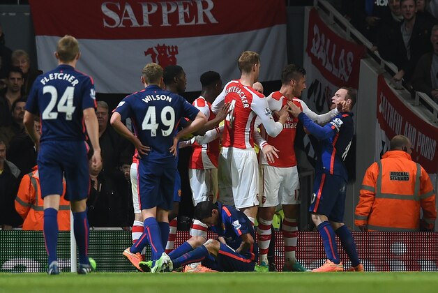 Manchester United’s Wayne Rooney, right, confronts Arsenal’s Oliver Giroud, second right, during the English Premier League soccer match between Arsenal and Manchester United at the Emirates Stadium, London, Saturday, Nov. 22, 2014. (AP Photo/Tim Ireland)