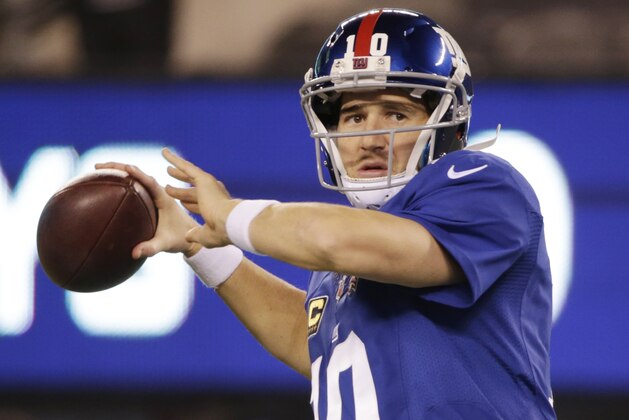 New York Giants quarterback Eli Manning (10) warms up before playing against the Dallas Cowboys in an NFL football game, Sunday, Nov. 23, 2014, in East Rutherford, N.J. (AP Photo/Julio Cortez)