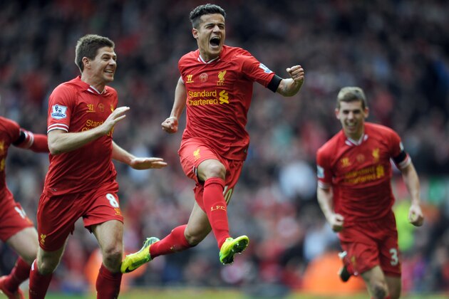 Liverpool's Philippe Coutinho, centre, celebrates with teammate Steven Gerrard, left, after he scored the third goal of the game for his side during their English Premier League soccer match against Manchester City at Anfield in Liverpool, England, Sunday April. 13, 2014. (AP Photo/Clint Hughes)