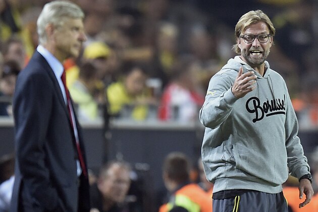 Arsenal's head coach Arsene Wenger, front, attends the match as Dortmund's head coach Juergen Klopp, right, shouts during the Champions League group D soccer match between Borussia Dortmund and Arsenal in Dortmund, Germany, Tuesday, Sept.16, 2014. Dortmund defeated Arsenal by 2-0.  (AP Photo/Martin Meissner)