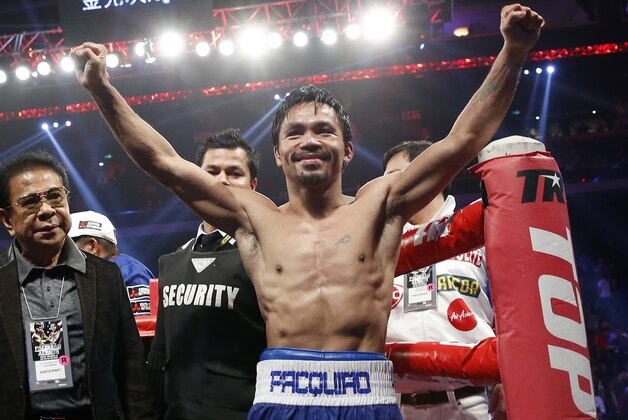WBO welterweight champion Manny Pacquiao celebrates after defeating WBO junior welterweight champion Chris Algieri of the U.S.  during their welterweight title boxing match at the Venetian Macao in Macau, Sunday, Nov. 23, 2014. Pacquiao got the big knockdowns he desperately craved, battering Algieri around the ring Sunday on his way to a decision win in a lopsided welterweight title fight.(AP Photo/Kin Cheung)