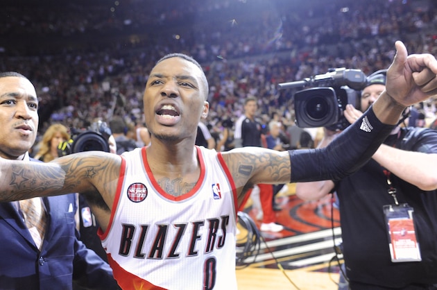 Portland Trail Blazers' Damian Lillard, center, celebrates with fans, his winning shot against the Houston Rockets during the last .9 of a second of game six of an NBA basketball first-round playoff series game in Portland, Ore., Friday May 2, 2014. The Trail Blazers won the series in a 99-98 win. (AP Photo/Greg Wahl-Stephens)