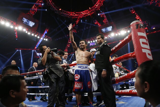 WBO welterweight champion Manny Pacquiao, center, of the Philippines celebrates after defeating WBO junior welterweight champion Chris Algieri of the United States during their world welterweight title boxing match at the Venetian Macao in Macau, Sunday, Nov. 23, 2014. (AP Photo/Kin Cheung)